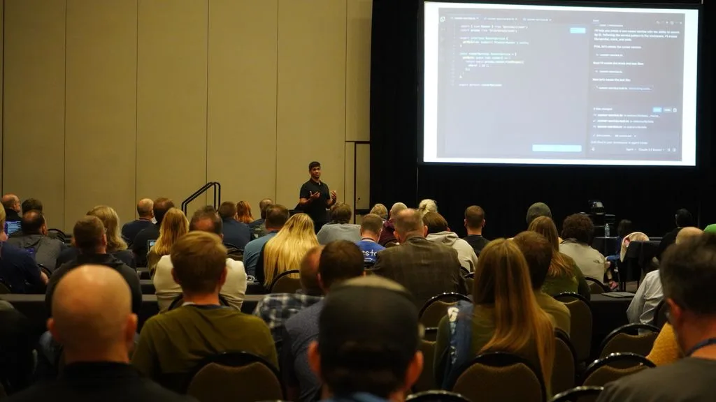 A full conference room watching Avindra run a live AI coding demo
