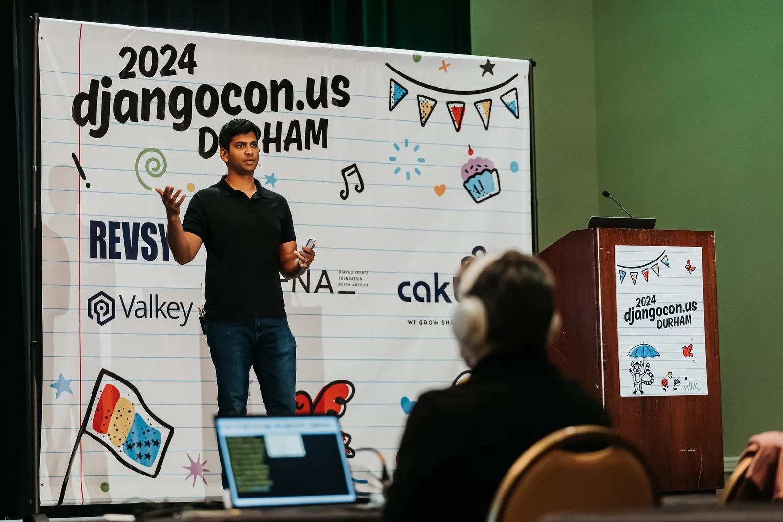 Avindra Fernando mid-talk in front of the DjangoCon US 2024 banner