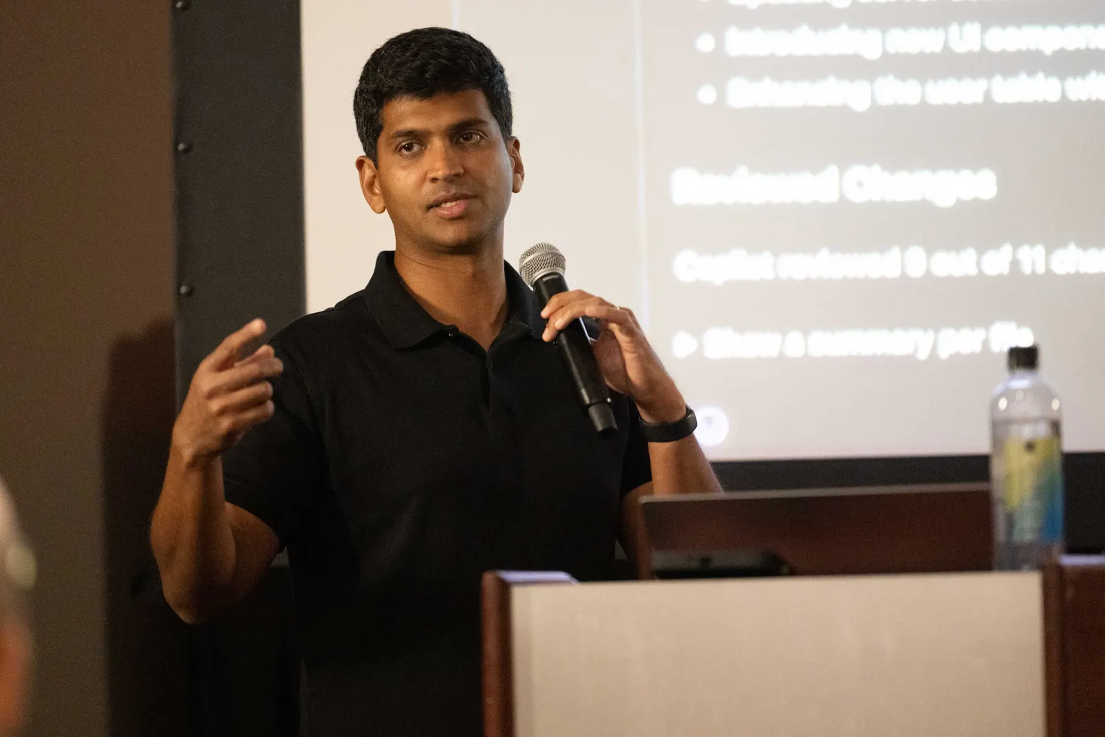 Avindra Fernando speaking about AI code review, mic in hand