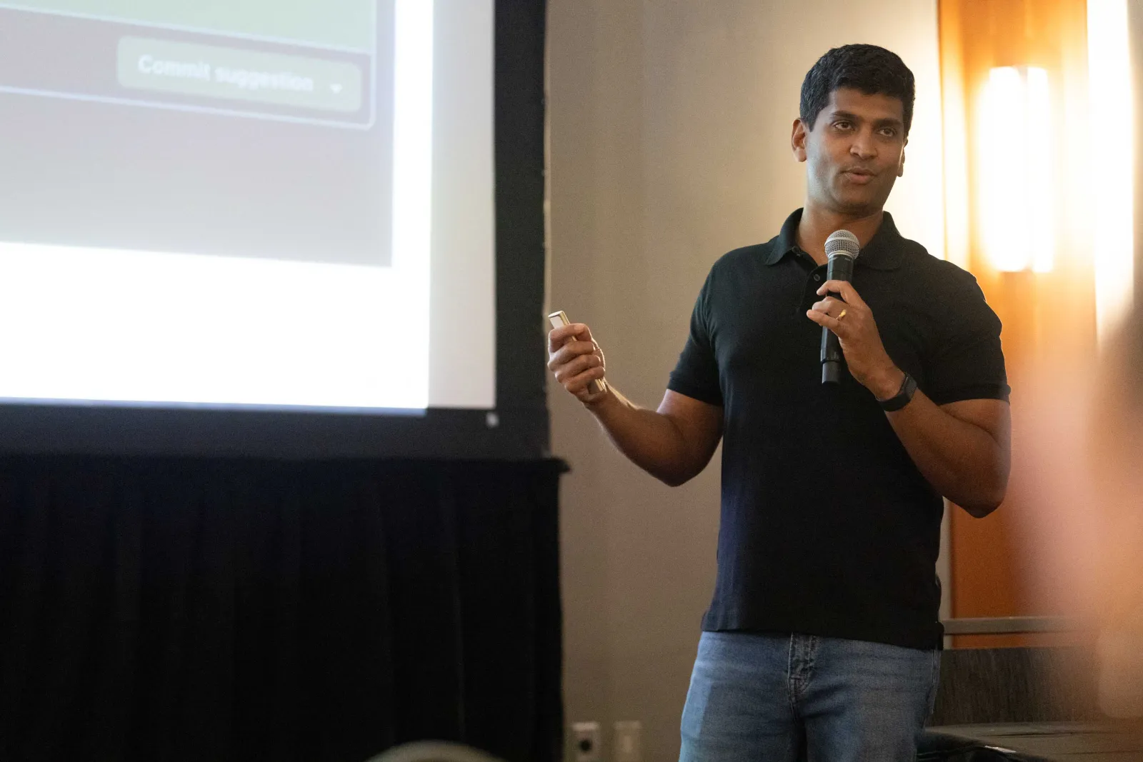 Avindra Fernando presenting with a mic, code review slide behind him